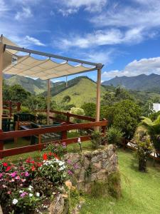 a patio with an umbrella and some flowers at Miradouro São Pedro da Serra in São Pedro da Serra