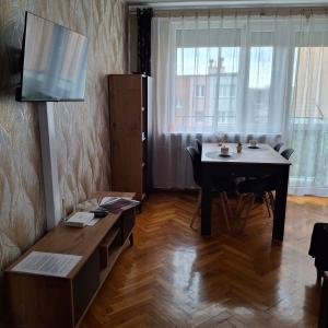 a living room with a dining room table and a television at Apartament Agnes in Gniezno