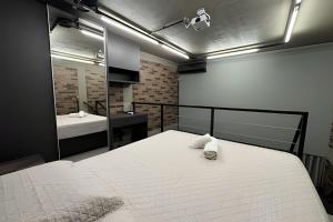 een slaapkamer met een groot wit bed en een spiegel bij Loft Encantador em Araxá in Araxá