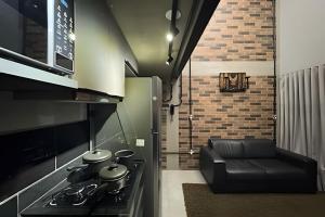 een keuken met een fornuis en een bank in een kamer bij Loft Encantador em Araxá in Araxá
