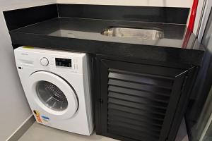 een keuken met een wasmachine en een wastafel bij Loft Encantador em Araxá in Araxá
