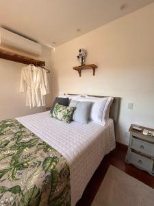 a bedroom with a bed with a green and white blanket at Miradouro São Pedro da Serra in São Pedro da Serra