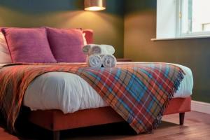 a bedroom with a bed with a blanket and towels at 89 The Merchants- Chic Aparthotel by The House of Danu in Edinburgh +140 photos