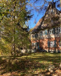 an old brick house with a tree in front of it at Widokówka in Łagów