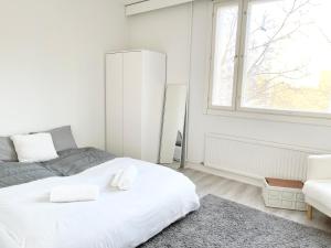 Un dormitorio blanco con una cama y una ventana. en Double bed room in An apartment with lovely cats, en Helsinki