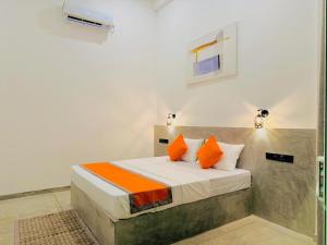 a bedroom with a bed with orange and white pillows at Bebe peak weligama in Weligama