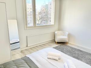 Un dormitorio con una cama y una silla y una ventana. en Double bed room in An apartment with lovely cats, en Helsinki