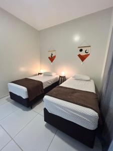 two beds in a small room with two at Casa Sóumi - Ubajara/CE in Ubajara