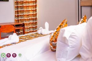 een wit bed met knuffels erop bij Twalumba Resort & Village in Mwanachunga