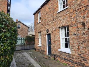 a brick house with a blue door and a fence at 7 Monk Bar Court YORK in York