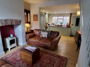 a living room with a leather couch and a table at 7 Monk Bar Court YORK in York