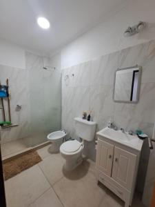 une salle de bains blanche avec toilettes et lavabo dans l'établissement rocamora, à Posadas