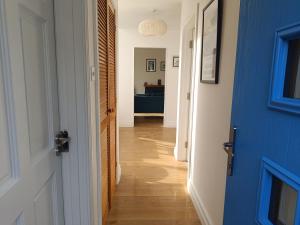 a hallway with a blue door and wooden floors at Cottage on the grounds of Rathmullan House Hotel in Rathmullan