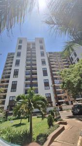 Un gran edificio blanco con palmeras delante. en The Glass Loft, en Nairobi