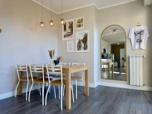 a dining room with a table and chairs and a mirror at Vespa Azzurra Boutique Apartment - Free Parking in Acquaseria +19 photos