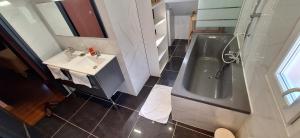 un baño con lavabo y bañera en L'Arche de Yves-Jody, en Saint-Jean-de-Braye 5 fotos más