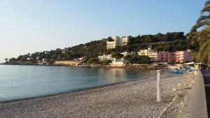 une plage avec des bâtiments sur une colline à côté de l'eau dans l'établissement Villa LaDoRe, Apt 2 chambres dans maison, 55m2, 100m des plages, parking, à Roquebrune-Cap-Martin
