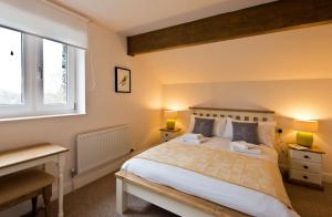 a bedroom with a large bed and two windows at Swarthmoor Hall in Ulverston