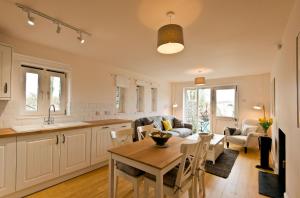 a kitchen and living room with a table and a couch at Swarthmoor Hall in Ulverston