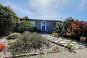 麦金利维尔Wavesong Refuge的一座带蓝色门和灌木的房子