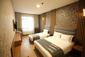 a hotel room with two beds and a window at Büpa Plus Hotel in Kayseri