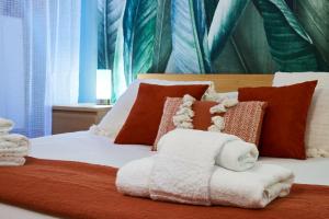 a bed with orange and white blankets and pillows at Rome Bloom - Navona in Rome +25 photos