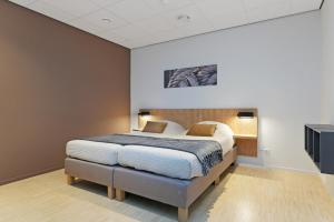 a bedroom with a large bed in a room at Dock Hotel Stellendam in Stellendam