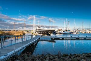 a dock with a boat in a marina with boats at Dock Hotel Stellendam in Stellendam +13 photos