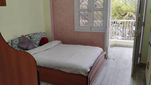 a small bedroom with a bed and a window at Neer Villa in Udaipur