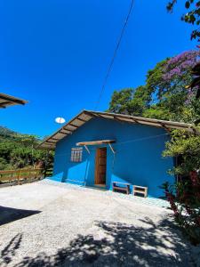 a blue building with a door in front at Rancho Pé da Pedra in São Bento do Sapucaí