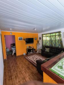 a living room with a couch and a tv at Rancho Pé da Pedra in São Bento do Sapucaí