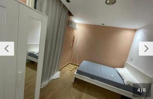 a small bedroom with a bed and a mirror at Style apartment in Cairo