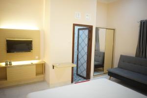 Zimmer mit einem Bett, einem Stuhl und einem Spiegel in der Unterkunft House of Toti in Yogyakarta