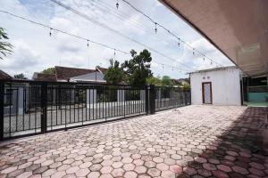 einen Balkon mit einem Zaun und Fliesenboden in der Unterkunft House of Toti in Yogyakarta
