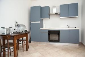 a kitchen with blue cabinets and a wooden table at CasArmando Casa Vacanze in Foligno
