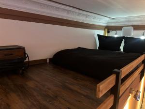a bedroom with a bed with black sheets and a wooden floor at Einzigartige Ferienwohnung bunt wie Berlin in Berlin