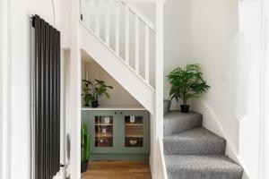 a hallway with stairs with potted plants at Stylish 2-Bedroom Townhouse in Stratford upon Avon in Stratford-upon-Avon +21 photos