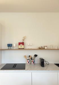 a kitchen counter with a sink and some shelves at La terrasse des sources in Spa