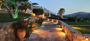 a stone retaining wall with potted plants and lights at Luxurious Villa Tholos Crete in Thólos +7 photos