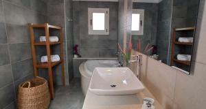 a bathroom with a sink and a toilet and a mirror at Luxurious Villa Tholos Crete in Thólos