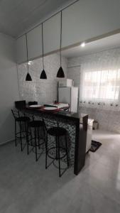 a kitchen with a bar with chairs and a counter top at KITNET DU VÔ - Cantinho Du Vô in Santa Teresa