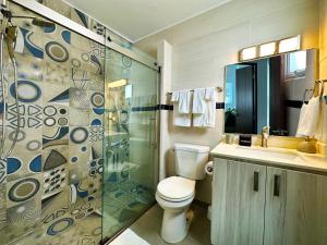 a bathroom with a toilet and a glass shower at Condado Laguna Villa I 6 bed 3 bath Jacuzzi in San Juan +32 photos