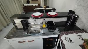 a small kitchen with a stove and a sink at KITNET DU VÔ - Cantinho Du Vô in Santa Teresa +5 photos