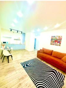 a living room with a red couch and a black and white rug at Ауельбекова 120 in Kokshetau +4 photos