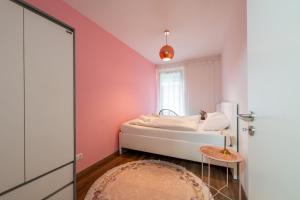 a bedroom with pink walls and a bed with a table at Central Premium Condo in Budapest