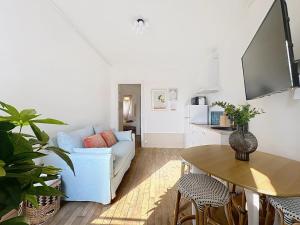 ein Wohnzimmer mit einer weißen Couch und einem Tisch in der Unterkunft Vesle- Hyper Centre - 2 Chambres in Reims