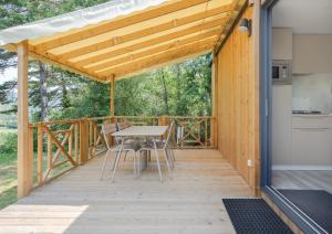 贝尔韦Camping RCN Le Moulin de la Pique的一个有桌子和椅子的木甲板