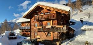 a log cabin in the snow with a car in front at Unterniggleralm in Thurn