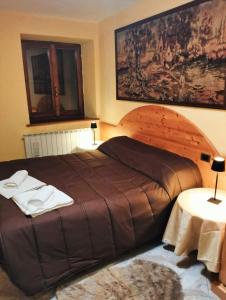 Vagli di SottoにあるHouse of serenityの大きなベッドとタオル2枚のある寝室