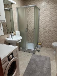 y baño con ducha y lavadora. en Stan u centru Niša, Obilićev venac, en Niš